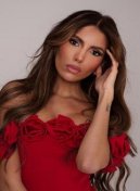 Livia, high class Latin escort in London, in a red off-shoulder rose dress