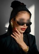 Veronica thumbnail - elite escort London in a black hooded outfit and sunglasses